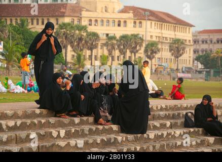 Sri Lanka: Studenti musulmani a Galle Face al tramonto, Colombo. Ci sono stati musulmani in Sri Lanka da oltre mille anni. Il commercio di dhow ha attraversato le acque tra il Medio Oriente e l'isola nota ai marinai arabi - come Sinbad - come Serendib anche in epoca pre-islamica. I primi mercanti e marinai musulmani potrebbero essere sbarcati sulle sue coste durante la vita di Maometto. Nel X secolo questa comunità prevalentemente araba era diventata abbastanza influente da controllare il commercio dei porti sud-occidentali, mentre i re singalesi generalmente impiegavano ministri musulmani per dirigere gli affari commerciali. Foto Stock