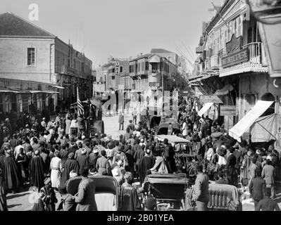 Palestina: Folle che guardano un rullo a vapore con una bandiera americana su una strada di Gerusalemme, 1911-1917. Palestina è un nome dato alla regione geografica tra il Mar Mediterraneo e il fiume Giordano. La regione è anche conosciuta come la Terra di Israele, la Terra Santa e il Levante meridionale. Nel 1832 la Palestina fu conquistata dall'Egitto di Muhammad Ali, ma nel 1840 la Gran Bretagna intervenne e restituì il controllo del Levante agli ottomani in cambio di ulteriori capitolazioni. La fine del XIX secolo vide l'inizio dell'immigrazione sionista e la rinascita della lingua ebraica. Foto Stock