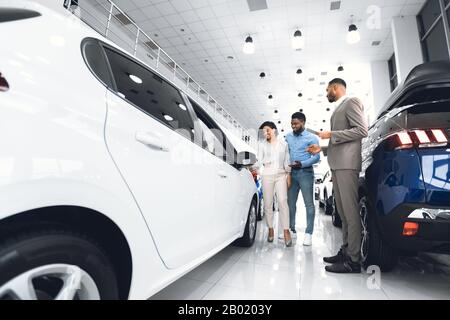 Auto Di Acquisto Della Famiglia, Concessionario Che Mostra Loro Auto Nel Dealership Store Foto Stock