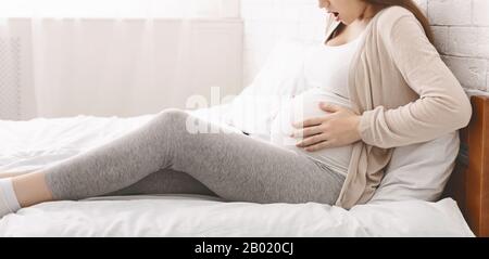 Donna incinta che soffre di contrazioni a casa Foto Stock