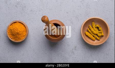 Curcuma in diverse forme polvere curcuma, radice su calcestruzzo Foto Stock