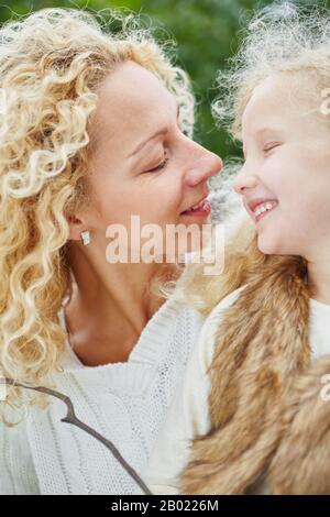 Madre e bambino con capelli ricci biondi parlano con attenzione l'uno con l'altro Foto Stock