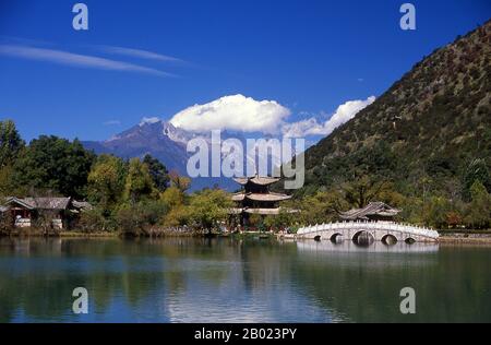 La piscina Black Dragon, costruita nel 1737 durante il periodo Qing, si trova leggermente a nord della città vecchia di Lijiang e offre una delle vedute piu' spettacolari della Cina. Jade Dragon Snow Mountain è una piccola catena montuosa) vicino a Lijiang, nella provincia di Yunnan della Cina sud-occidentale. La sua cima più alta è chiamata Shanzidou (5.596 m o 18.360 ft). Il lato lontano della montagna forma un lato della gola di salto della tigre (Hutiao Xia). Foto Stock