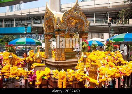 Thailandia: Santuario di Erawan (San Phra Phrom), Bangkok. Il Santuario di Erawan, sotto la stazione Chit Lom Skytrain di Bangkok, rappresenta il Dio indù a quattro teste della creazione, Brahma (Phra Phrom), ed è stato eretto nel 1956 dopo una serie di incidenti mortali alla costruzione dell'originale Hotel Erawan. Brahmā è il dio indù della creazione e uno dei Trimūrti, gli altri sono Vishnu e Shiva. Secondo il Brahmā Purāņa, egli è il padre di Manu, e da Manu tutti gli esseri umani sono discendenti. Nella Rāmāyaņa e nella Mahābhārata, egli è indicato come il progenitore di tutti gli esseri umani. Foto Stock