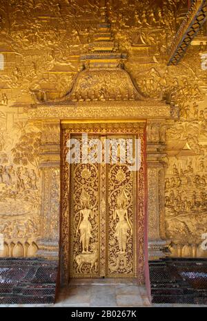 Wat mai Suwannaphumaham risale ai primi del 19th secolo. Il tempio era una volta la residenza del Sangkhalat, il supremo patriarca del Buddismo in Laos. la sim (sala di ordinazione) è in legno, con un tetto a cinque piani in classico stile Luang Prabang. L'attrazione principale del sim sono le pareti dorate della veranda anteriore, i cui disegni raccontano scene della Ramayana e della penultima incarnazione del Buddha (Vessantara Jataka). Per la prima metà del 20th secolo il Phra Bang (immagine del Buddha reale nel mudra Paura di abbattimento) è stato ospitato all'interno del sim, ed è ancora messo in mostra Foto Stock