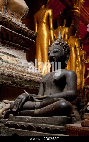 Wat mai Suwannaphumaham risale ai primi del 19th secolo. Il tempio era una volta la residenza del Sangkhalat, il supremo patriarca del Buddismo in Laos. la sim (sala di ordinazione) è in legno, con un tetto a cinque piani in classico stile Luang Prabang. L'attrazione principale del sim sono le pareti dorate della veranda anteriore, i cui disegni raccontano scene della Ramayana e della penultima incarnazione del Buddha (Vessantara Jataka). Per la prima metà del 20th secolo il Phra Bang (immagine del Buddha reale nel mudra Paura di abbattimento) è stato ospitato all'interno del sim, ed è ancora messo in mostra Foto Stock