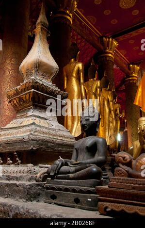 Wat mai Suwannaphumaham risale ai primi del 19th secolo. Il tempio era una volta la residenza del Sangkhalat, il supremo patriarca del Buddismo in Laos. la sim (sala di ordinazione) è in legno, con un tetto a cinque piani in classico stile Luang Prabang. L'attrazione principale del sim sono le pareti dorate della veranda anteriore, i cui disegni raccontano scene della Ramayana e della penultima incarnazione del Buddha (Vessantara Jataka). Per la prima metà del 20th secolo il Phra Bang (immagine del Buddha reale nel mudra Paura di abbattimento) è stato ospitato all'interno del sim, ed è ancora messo in mostra Foto Stock