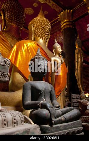 Wat mai Suwannaphumaham risale ai primi del 19th secolo. Il tempio era una volta la residenza del Sangkhalat, il supremo patriarca del Buddismo in Laos. la sim (sala di ordinazione) è in legno, con un tetto a cinque piani in classico stile Luang Prabang. L'attrazione principale del sim sono le pareti dorate della veranda anteriore, i cui disegni raccontano scene della Ramayana e della penultima incarnazione del Buddha (Vessantara Jataka). Per la prima metà del 20th secolo il Phra Bang (immagine del Buddha reale nel mudra Paura di abbattimento) è stato ospitato all'interno del sim, ed è ancora messo in mostra Foto Stock