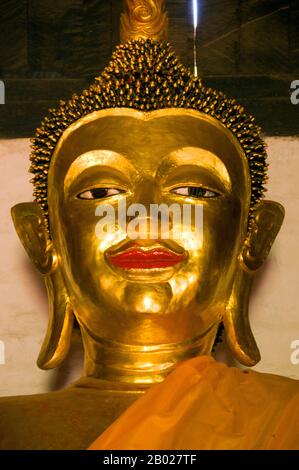 Thailandia: Immagine di Buddha nel viharn, Wat Pa Daet, Mae Chaem, Provincia di Chiang mai. Wat Pa Daet; il nome - "bosco illuminato dal sole" - indica che in passato era un tempio della foresta. Un recinto murato contiene un viharn, sala e ho trai o biblioteca, mentre appena fuori si trova un ubosot in stile tradizionale settentrionale, circondato da uno stretto fossato. Il viharn risale al 1877 ed è stato accuratamente restaurato a metà degli anni '1980 Decorato in nero e oro, il tetto a tre livelli si abbassa nel tipico stile Lanna, con elaborati frontoni alati che supportano la naga svasata. Foto Stock
