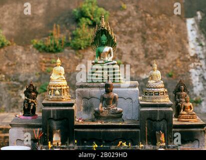 Thailandia: Piccolo santuario con figure di Buddha di fronte al grande chedi principale, Wat Chedi Luang, Chiang mai. Wat Chedi Luang si traduce letteralmente dal thailandese come «Monastero del grande Stupa». La costruzione del tempio iniziò alla fine del XIV secolo, quando il regno LAN Na era al suo apice. Re Saen Muang ma (1385-1401) lo ha concepito come il sito di un grande reliquiario per custodire le ceneri di suo padre, re Ku Na (1355-1385). Oggi è il sito del Lak Muang o pilastro della città. La cerimonia annuale Inthakin si svolge all'interno dei confini del tempio. Foto Stock