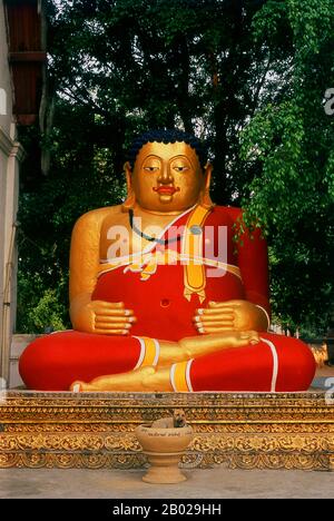 Thailandia: Buddha grasso e cane, Wat Chedi Luang, Chiang mai. Wat Chedi Luang si traduce letteralmente dal thailandese come «Monastero del grande Stupa». La costruzione del tempio iniziò alla fine del XIV secolo, quando il regno LAN Na era al suo apice. Re Saen Muang ma (1385-1401) lo ha concepito come il sito di un grande reliquiario per custodire le ceneri di suo padre, re Ku Na (1355-1385). Oggi è il sito del Lak Muang o pilastro della città. La cerimonia annuale Inthakin si svolge all'interno dei confini del tempio. Foto Stock