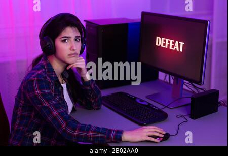 Ragazza Triste Che Perde Gioco Del Calcolatore Giocando Sul Pc Alla Sede Foto Stock