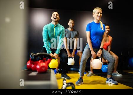 Fitness, sport, allenamento, palestra, successo e stile di vita. Gruppo di amici felici in palestra Foto Stock