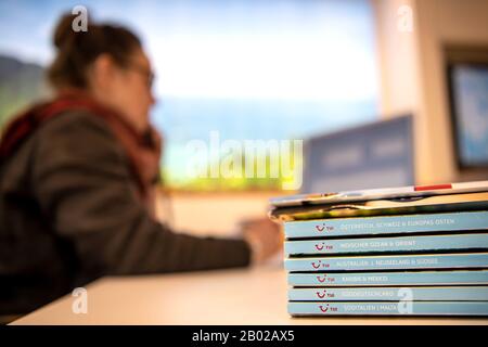 Hannover, Germania. 09th dicembre 2019. Illustrazione - un dipendente dell'interfaccia telefonica utente si trova dietro una serie di cataloghi nell'agenzia di viaggi. Credito: Sina Schuldt/Dpa/Alamy Live News Foto Stock