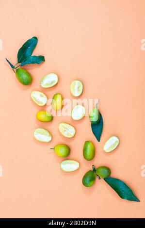 Frutta kumquat tagliato a metà, su sfondo giallo, orientamento verticale. Copia spazio Foto Stock