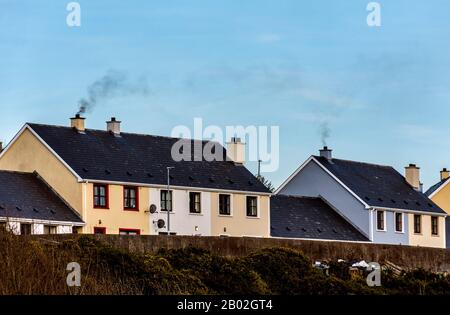 Fumo dalla combustione di combustibili fossili soffia nel cielo di Ardara, County Donegal, Irlanda Foto Stock