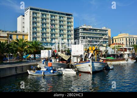 Kavala, Grecia - settembre 17th 2015: Costruzione di Hotel Galaxy e barche da pesca sul porto della città Foto Stock