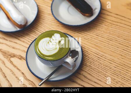 Matcha verde con un'eclair. Accogliente caffetteria. Foto Stock