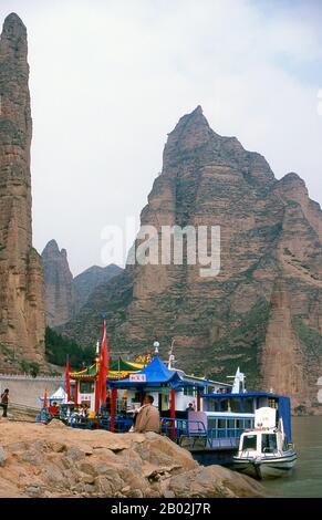 Il fiume giallo (Huang He), è la via d'acqua più importante della Cina. La regione intorno alla confluenza dei fiumi Huang He e Wei formò la culla della civiltà cinese. Il fiume è il terzo fiume più lungo dell'Asia, seguendo il fiume Yangtze e il fiume Yenisei, e il sesto più lungo del mondo, con una lunghezza stimata di 5.464 km (3.395 mi). Binglingsi Shiku (Thousand Buddha Caves) è una collezione di grotte e grotte, situata in un canyon inaccessibile dal fiume giallo a circa 80km a monte di Lanzhou. L'isolamento del sito ha protetto e conservato Binglingsi, non da ultimo da mar Foto Stock