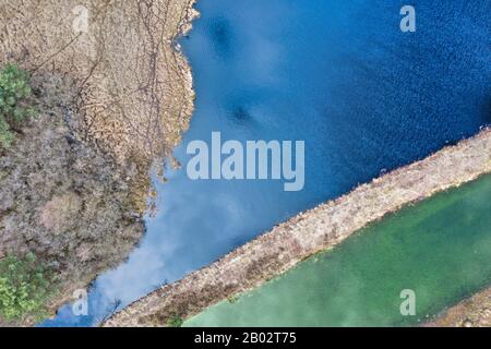 Veduta aerea astratta di un lago nel paesaggio tedesco di brughiera, foto Verticale sopra il centro del lago di brughiera Foto Stock