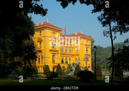 Il Palazzo Presidenziale fu originariamente costruito nel 1901 per Paul Doumer, allora governatore dell'Indocina francese. Dipinta nella mostarda scura gialla in pietra con le finestre verdi e le persiane louvered così favorite in Vietnam, ora è impiegato principalmente per ricevere dignitari in visita e capi di stato. L'eroe nazionale vietnamita, ho Chi Minh, che divenne presidente della Repubblica democratica del Vietnam nel 1954, rifiutò di vivere qui. Secondo il suo biografo Duiker: ‘rifiutò un’offerta da parte dei suoi colleghi di vivere nel Palazzo del Governatore Generale, che considerava troppo pretenziosa per i cipressi Foto Stock