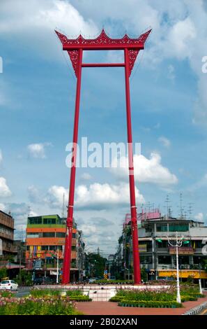 Deve essere una delle attrazioni più curiose di Bangkok, la cosiddetta Swing gigante, una struttura in legno di 25 m di altezza, rosso sangue, che si erge di fronte al Wat (Tempio) Suthat. L'altalena gigante, in Sao-Ching-Cha tailandese ('pilastri di canto'), consiste di due pilastri solidi che sono collegati alla loro sommità con un fascio di legno. Da questo fascio, nei giorni passati, i fedeli di Lord Shiva usavano oscillare in una sorta di gondola per l'intrattenimento del loro dio. Potrebbero anche guadagnarsi dei soldi: Una borsa di soldi era legata ad uno dei pilastri e i partecipanti dovevano afferrarlo con i denti. Tabella Di Previsione Foto Stock