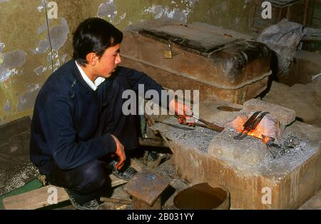 La piccola oasi dominata dagli uiguri di Yengisar (Yingjisha) è conosciuta in tutta la provincia cinese occidentale dello Xinjiang per la produzione di coltelli fatti a mano. La fabbrica di coltelli piccoli (Pichak Chilik Karakhana / Xiaochang) impiega abili artigiani locali che producono coltelli sottili con manici intarsiati. Appena circa ogni uomo di Uighur porta un coltello, sia come segno di manhood che per lo scopo più utilitaristico di tagliare i meloni ed il più stimato (e costoso) viene da Yengisar. Foto Stock
