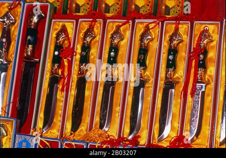 La piccola oasi dominata dagli uiguri di Yengisar (Yingjisha) è conosciuta in tutta la provincia cinese occidentale dello Xinjiang per la produzione di coltelli fatti a mano. La fabbrica di coltelli piccoli (Pichak Chilik Karakhana / Xiaochang) impiega abili artigiani locali che producono coltelli sottili con manici intarsiati. Appena circa ogni uomo di Uighur porta un coltello, sia come segno di manhood che per lo scopo più utilitaristico di tagliare i meloni ed il più stimato (e costoso) viene da Yengisar. Foto Stock