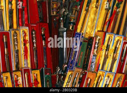 La piccola oasi dominata dagli uiguri di Yengisar (Yingjisha) è conosciuta in tutta la provincia cinese occidentale dello Xinjiang per la produzione di coltelli fatti a mano. La fabbrica di coltelli piccoli (Pichak Chilik Karakhana / Xiaochang) impiega abili artigiani locali che producono coltelli sottili con manici intarsiati. Appena circa ogni uomo di Uighur porta un coltello, sia come segno di manhood che per lo scopo più utilitaristico di tagliare i meloni ed il più stimato (e costoso) viene da Yengisar. Foto Stock