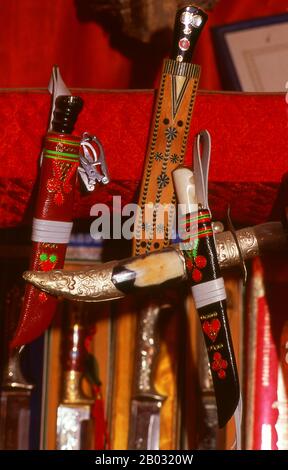 La piccola oasi dominata dagli uiguri di Yengisar (Yingjisha) è conosciuta in tutta la provincia cinese occidentale dello Xinjiang per la produzione di coltelli fatti a mano. La fabbrica di coltelli piccoli (Pichak Chilik Karakhana / Xiaochang) impiega abili artigiani locali che producono coltelli sottili con manici intarsiati. Appena circa ogni uomo di Uighur porta un coltello, sia come segno di manhood che per lo scopo più utilitaristico di tagliare i meloni ed il più stimato (e costoso) viene da Yengisar. Foto Stock