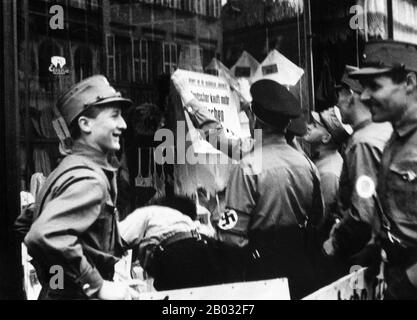 Kristallnacht o 'Crystal Night', chiamata anche Notte Del vetro Rotto, era un pogrom contro gli ebrei in tutta la Germania nazista e l'Austria che ha avuto luogo il 9-10 novembre 1938, eseguito da SA (Sturmabteilung o Brownshirts) forze paramilitari e civili tedeschi. Le autorità tedesche si sono esaminate senza intervenire. Il nome Kristallnacht deriva dalle barbe di vetro rotto che costellavano le strade dopo che i negozi, gli edifici e le sinagoghe di proprietà ebraica avevano le loro finestre schiacciate. Foto Stock