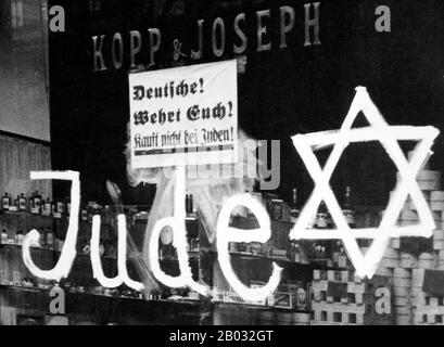 Kristallnacht o 'Crystal Night', chiamata anche Notte Del vetro Rotto, era un pogrom contro gli ebrei in tutta la Germania nazista e l'Austria che si svolse il 9-10 novembre 1938, eseguito da forze paramilitari di SA e civili tedeschi. Le autorità tedesche si sono esaminate senza intervenire. Il nome Kristallnacht deriva dalle barbe di vetro rotto che costellavano le strade dopo che i negozi, gli edifici e le sinagoghe di proprietà ebraica avevano le loro finestre schiacciate. Foto Stock