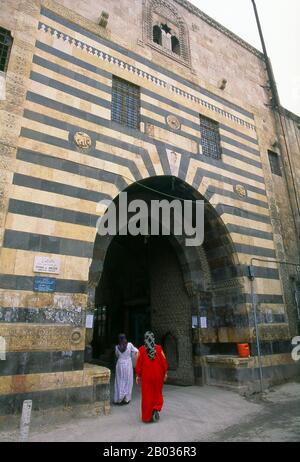 Il Grande Bazar di Aleppo (in arabo, suq o souq) come sappiamo oggi è stato ricostruito prima dai Mamelukes egiziani che hanno scacciato i Mongoli, e poi, dopo il 1516, dai Turchi che hanno incorporato Aleppo nell'Impero Ottomano. Durante la guerra civile siriana, iniziata nel 2011, i suq storici di Aleppo subirono gravi danni. Aleppo, la seconda città della Siria e forse il più lungo insediamento abitato del mondo, è di venerabile età. Così vecchio, infatti, che il suo nome arabo, Halab, è menzionato per la prima volta nei testi semitici del terzo millennio a.C.. Situato nel nord-ovest del Foto Stock