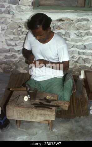 Sul bordo orientale dell'Atollo di Nilandhoo Sud si trova la piccola isola di Rinbudhoo. Qui, in uno dei villaggi più tranquilli e puliti delle Maldive, vive l'unico gruppo di orafi ereditari del paese. Fondendo sovrani d'oro vittoriani e thaler Marie-Therèse come casualmente come piccoli lingotti importati di recente da Dubai, essi producono una squisita gamma di catene, collane, orecchini, anelli di dita e amuleti. La nazione più piccola e meno conosciuta dell'Asia, la Repubblica delle Maldive, si trova disseminata da nord a sud attraverso un'apertura di 750 chilometri dell'Oceano Indiano a 500 chilometri a sud di wes Foto Stock