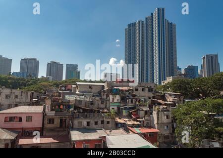 Metro Manila, Filippine - 12 febbraio 2020: Paesaggio urbano di Makati e BGC: Baraccopoli e grattacieli a contrasto Foto Stock