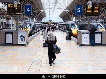 Stazione ferroviaria - passeggeri della ferrovia che arrivano in treno - persone che camminano verso la piattaforma e i treni, Paddington Station, Londra UK Foto Stock