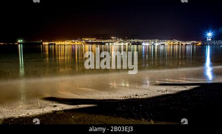 Giordania, Israele Ed Egitto. Lunga esposizione sulla costa del Golfo di Aqaba sul Mar Rosso, notte invernale. Viaggio in Medio Oriente, regno di Giordania. Tre paesi presentati in una sola fotografia, riflessioni sull'acqua Foto Stock