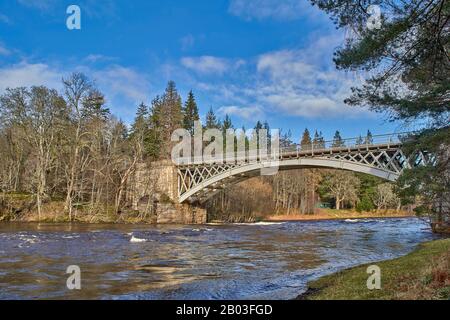 CARRON VILLAGE MORAY SCOTLAND UNA VISTA DELLA STRUTTURA UNICA DI CARRON STRADA E VECCHIO PONTE FERROVIARIO CHE ATTRAVERSA IL FIUME SPEY E LA CAPANNA VERDE DI PESCA Foto Stock