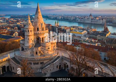 Budapest, Ungheria - la torre principale del famoso Bastione dei pescatori (Halaszbastya) dall'alto con il Parlamento e il Danubio sullo sfondo Foto Stock