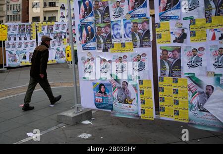 Teheran, Iran. 17th Feb, 2020. Un uomo cammina oltre i manifesti elettorali dei candidati per le prossime elezioni parlamentari a Teheran, Iran, il 17 febbraio 2020. Il 21 febbraio il popolo iraniano andrà alle urne per eleggere i legislatori per il parlamento a 290 seggi. Credito: Ahmad Halabisaz/Xinhua/Alamy Live News Foto Stock