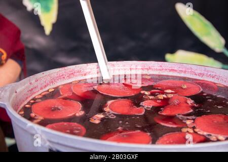 Grande casseruola con VIN brulé arance tritate e spezie Street food fascival arancia fragola VIN brulé in una grande casseruola al festival di s. Foto Stock