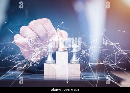 Business man holding golden re scacchi al vincitore posizione sul cubo di legno del gioco degli scacchi Foto Stock