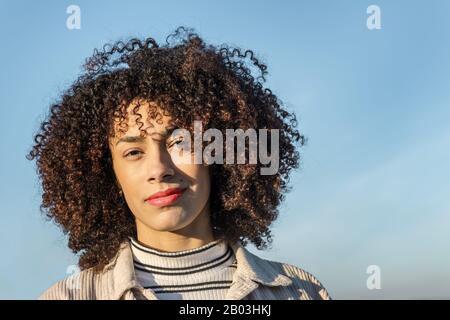 ritratto di una bella afro americana giovane donna con capelli ricci afro, concetto di bellezza, gioventù e diversità, copia spazio per il testo Foto Stock