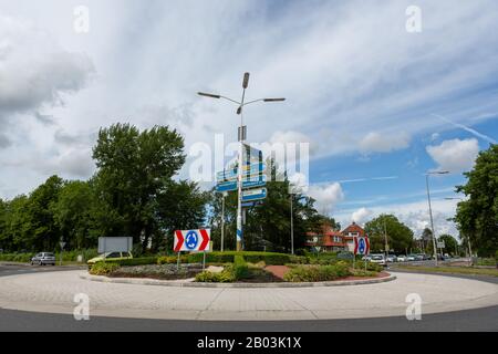 Auto entrando in una rotonda con indicazioni stradali sul van Pallandtlaan nel villaggio di Sassenheim nei Paesi Bassi. Foto Stock