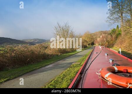 Vista da un battello a narrowboat che viaggia in un paesaggio rurale inglese sul canale navigabile britannico Foto Stock