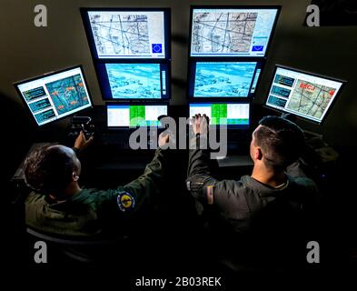 Un pilota istruttore dell'aeronautica statunitense, a sinistra, convogli un pilota studentesco durante un simulatore di volo di missione dei droni Predator Reaper allo squadrone 558th Flying Training, base congiunta di San Antonio, 17 luglio 2018 a San Antonio, Texas. Gli studenti piloti trascorrono 85 giorni nel corso di qualificazione dello strumento RPA e 30 giorni nel corso Nozioni di base RPA durante la seconda fase del programma pilota di istruzione e formazione aerea. Foto Stock
