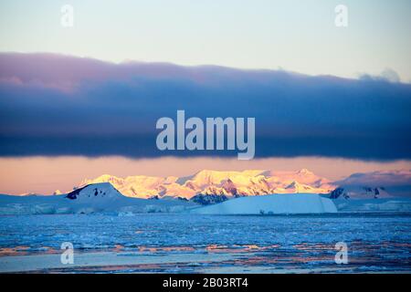 Guardando verso l'isola di Anvers al tramonto dal canale Lemaire, l'Antartide. Foto Stock