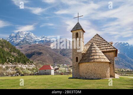 Chiesa del villaggio nella Valle Theth con montagne innevate sullo sfondo, in Albania Foto Stock