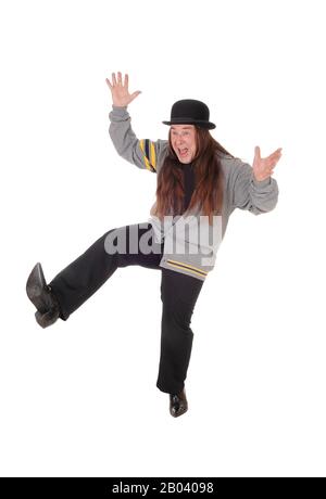 Un uomo indigeno in grigio di una giacca e pantaloni neri saltando per la felicità nell'aria, isolato per sfondo bianco Foto Stock