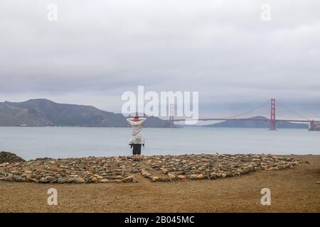 San Francisco, California - 21 gennaio 2020: Una donna che si trova vicino al Labyrinth Lands End e che guarda al lontano Golden Gate Bridge di San Francisco Foto Stock